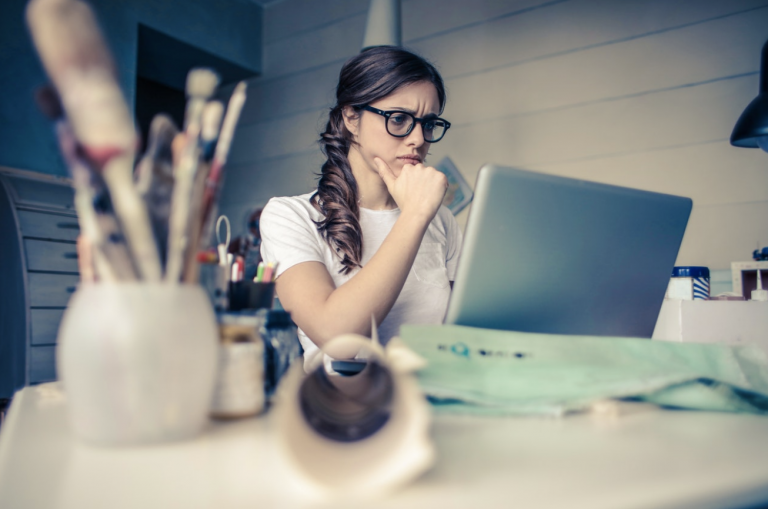 Woman thinking while using a laptop